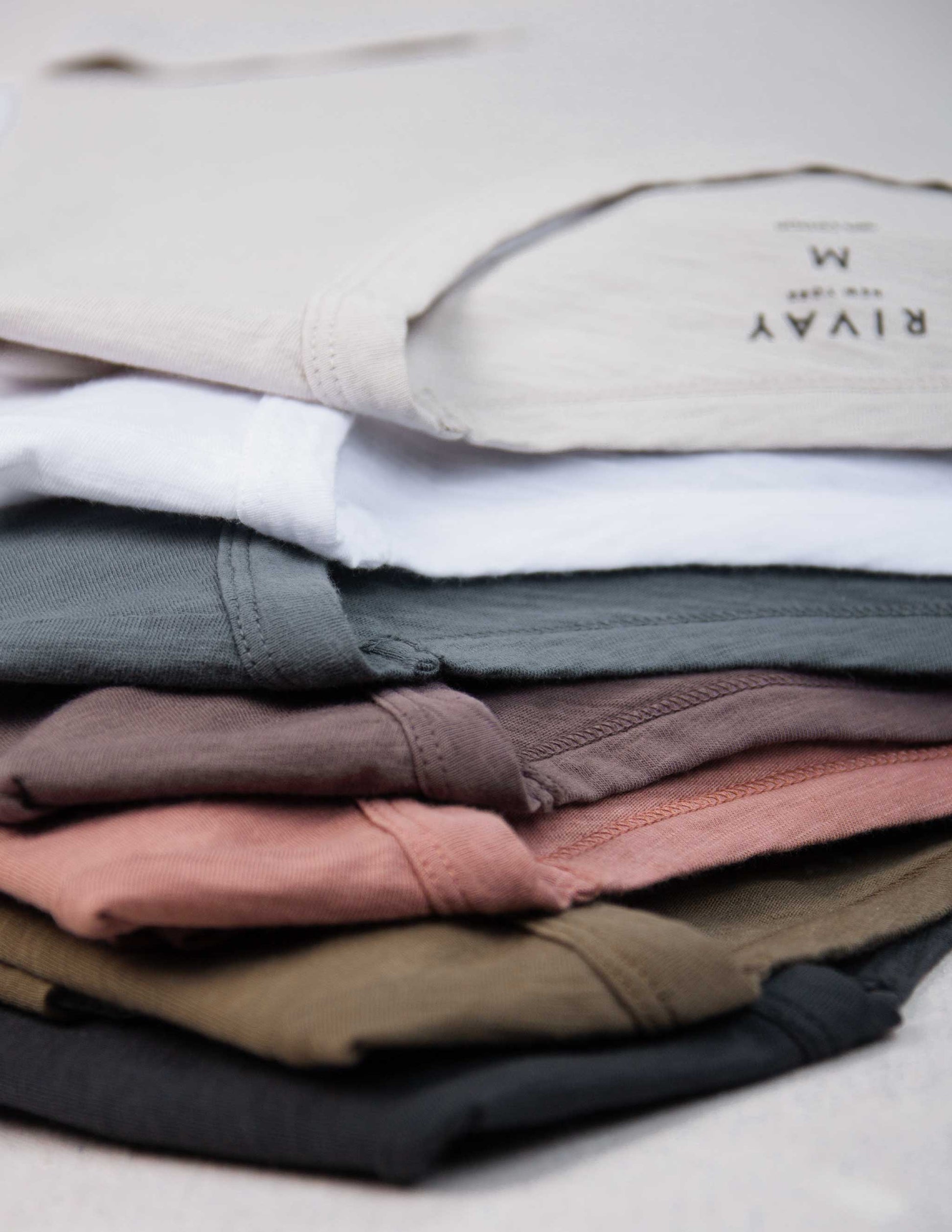 Stack of folded Rivay slub t-shirts in various colors