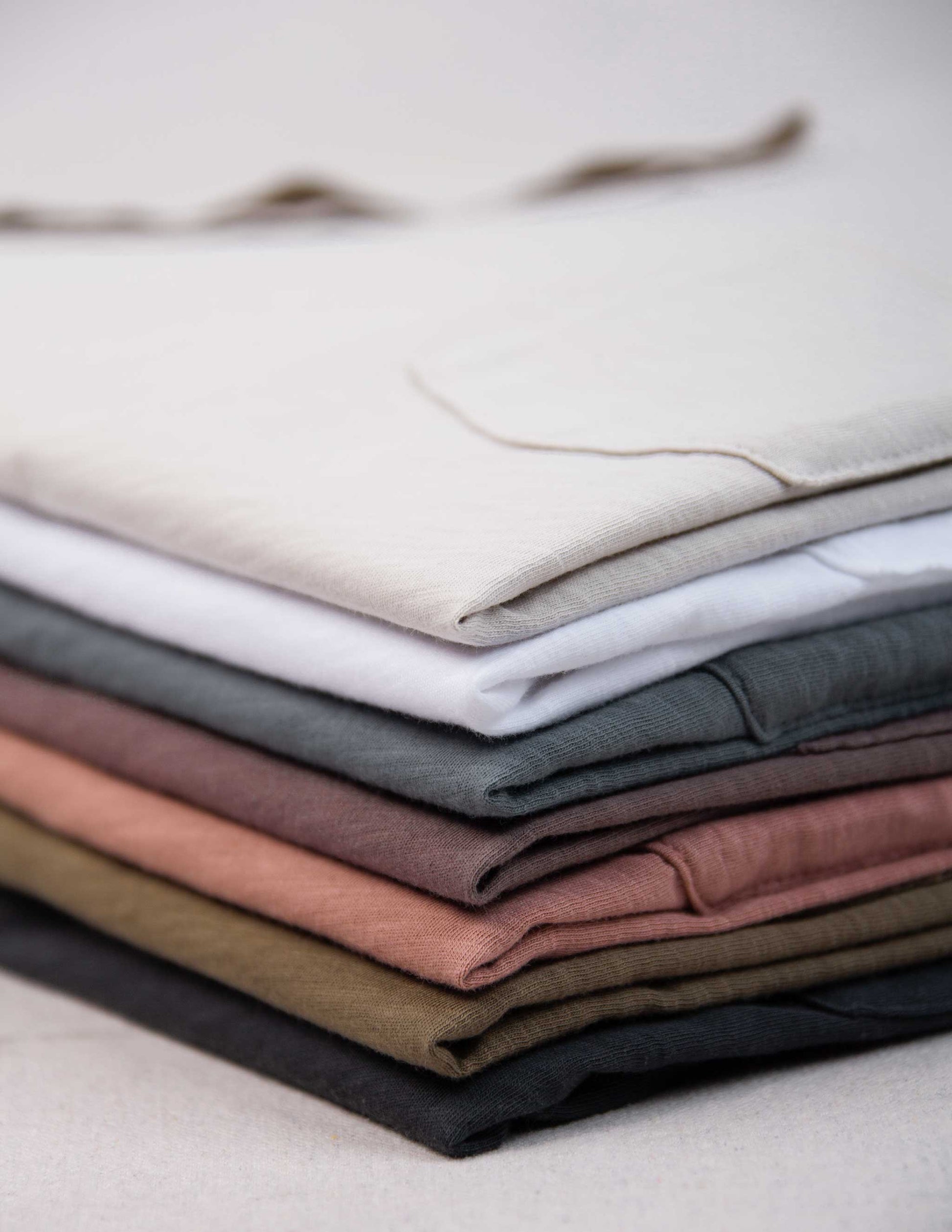 Stack of folded Rivay slub t-shirts in various colors
